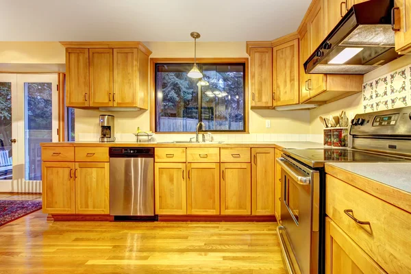 Golden wood kitchen with hardwood floor.