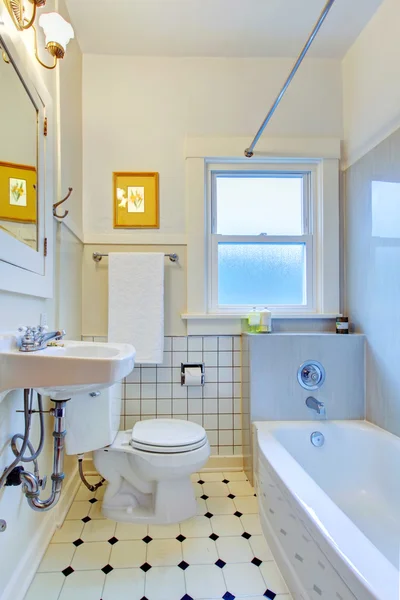 White old bathroom with tiles and tub.