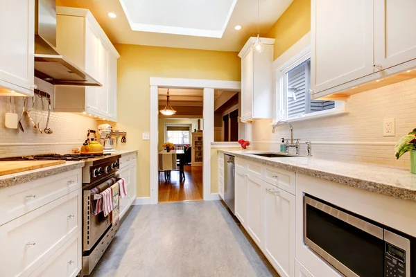Yellow and white simple kitchen with skylight.
