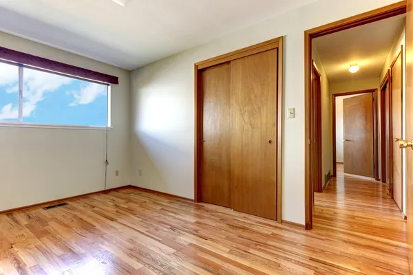 Empty bedroom with shiny hardwood floor.