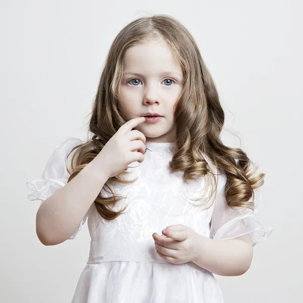 Portrait of a beautiful little girl in a white dress and veil on a white background