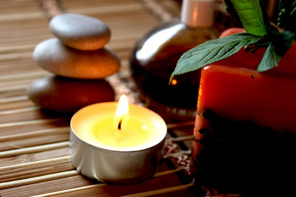 Spa candle, massage stones and oils