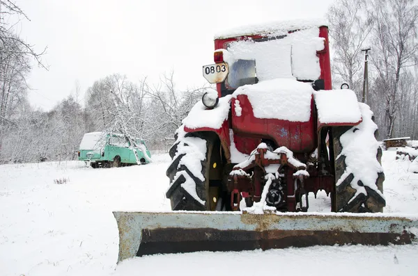Old russian soviet tractor covered snow in winter