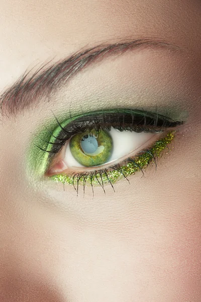 Eye of woman with green make-up