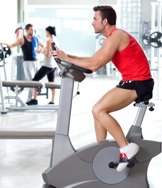Man on stationary bicycle at sport fitness gym