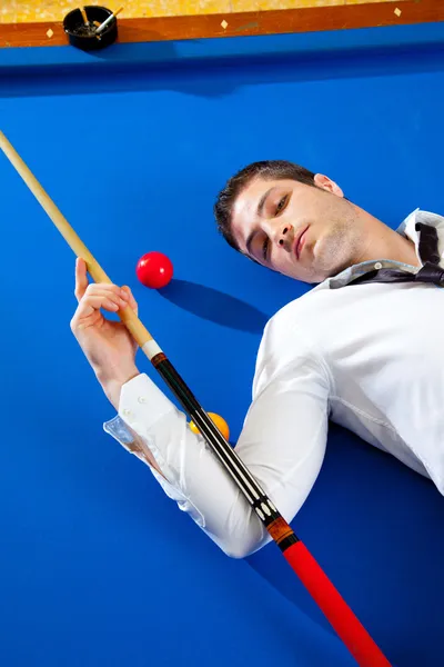 Billiard young man player lying on pool blue table