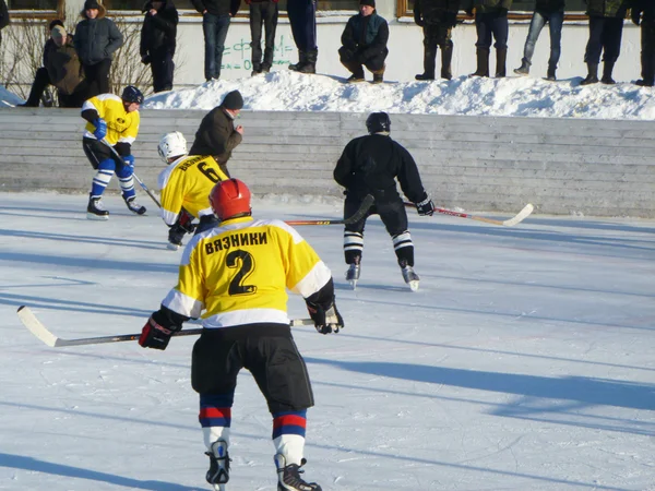 Hockey play of the commands on skating rink outdoors