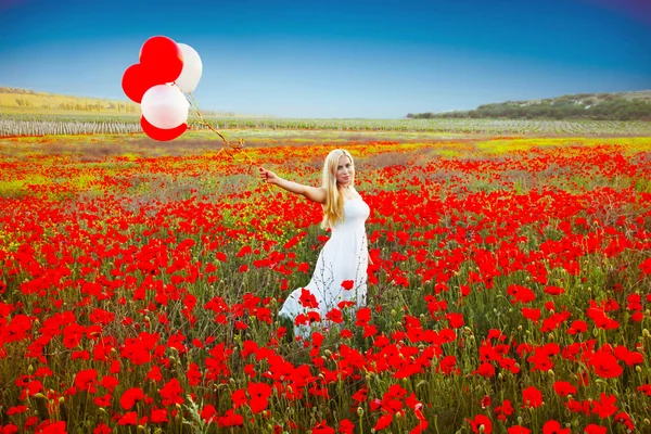 Portrait of romantic woman in poppy field in white dress