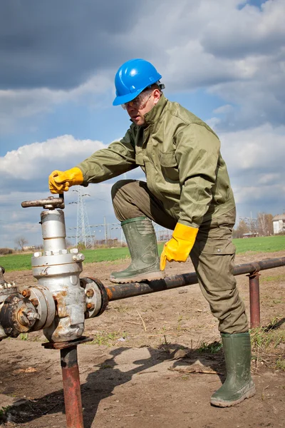 Worker in the oil industry on oil pump