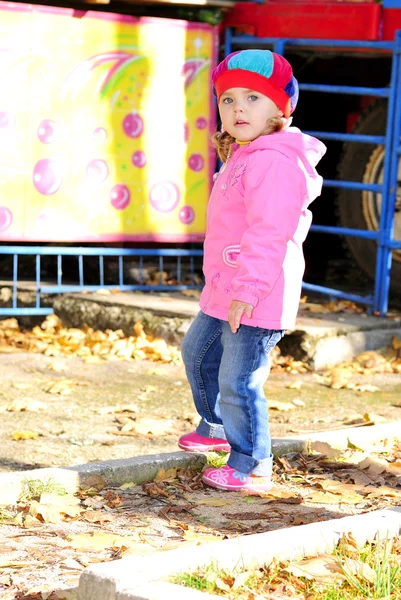 The little girl walks in autumn park