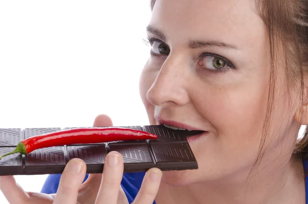 Woman eating chocolate with chili pepper