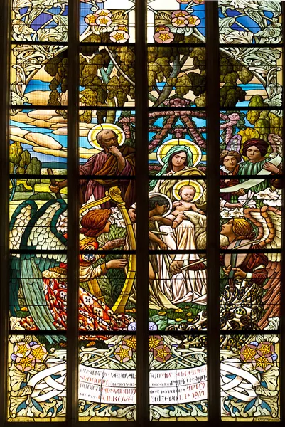 Stained glass window in old church with four saints person praying