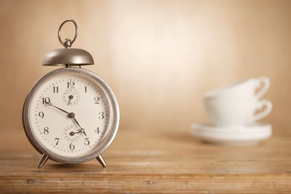 5 o\'clock tea time, retro alarm and white tea cups on background