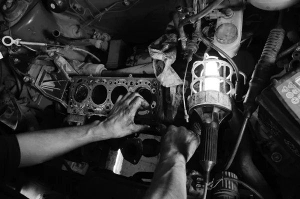 Hands of a worker repairing car