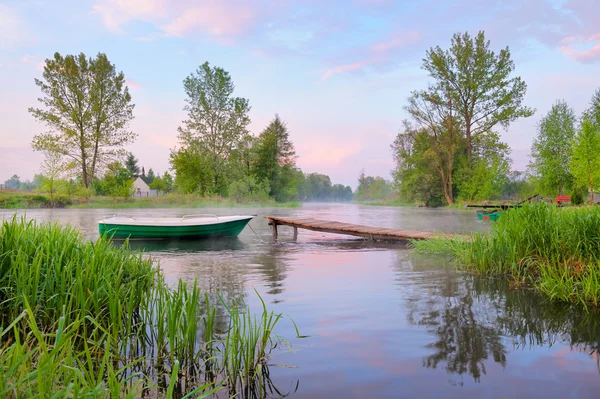 Rural landscape with boat and footbridge on the Narew river