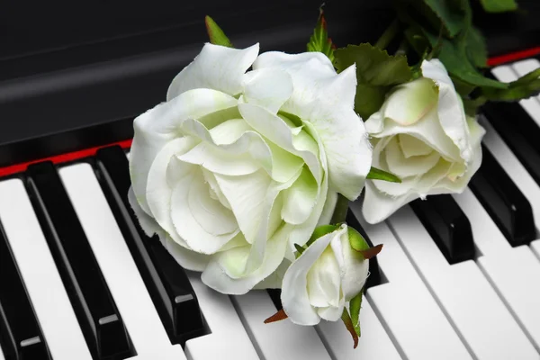 Artificial white rose on piano — Stock Photo #9044725
