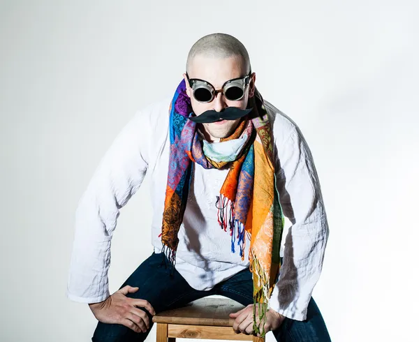 Man with false moustache and colored scarf