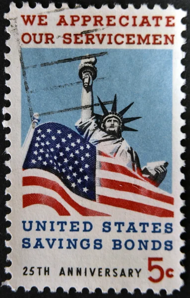 UNITED STATES OF AMERICA - CIRCA 1966: A stamp printed in USA dedicated to Honoring American servicemen and US savings bonds, shows Statue of Liberty and American Flag, circa 1966