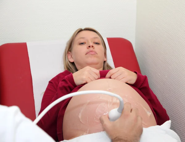 Pregnant woman getting ultrasound examination from doctor