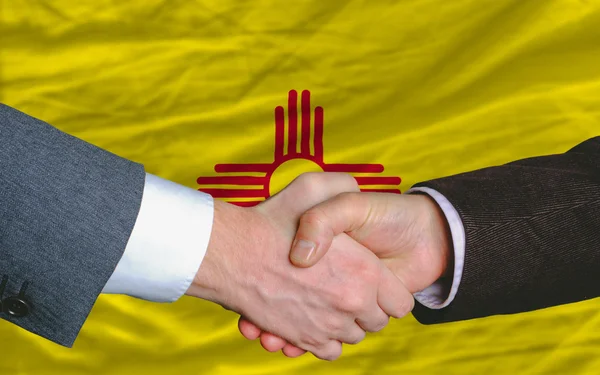 In front of american state flag of new mexico two businessmen ha — Stock Photo #8742071