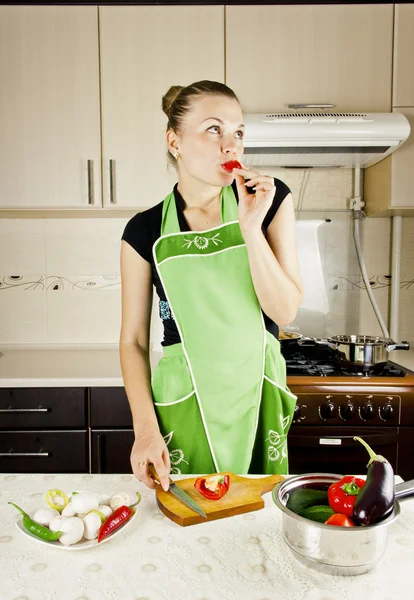 Young woman cooks dinner in the kitchen