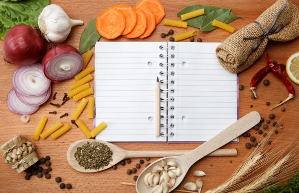 Notebook for recipes and spices on wooden table