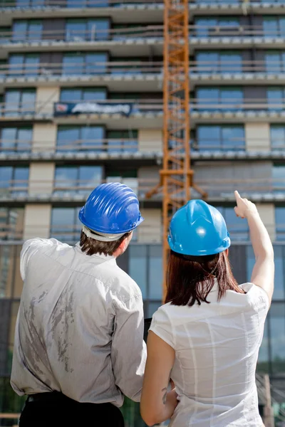 Female construction engineer pointing on a building at construct