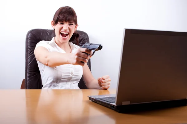 Young businesswoman losing her temper and about to shoot her lap — Stock Photo #8848774