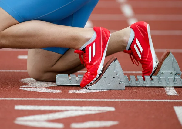 Detailed view of a sprinter in the starting blocks