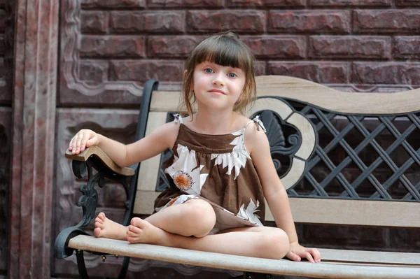 Portrait of cute smiling child sitting on bench