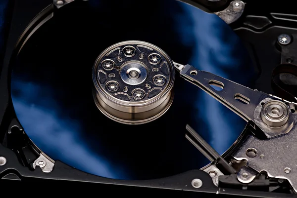 The disassembled hard disk of the computer on a dark blue backgr