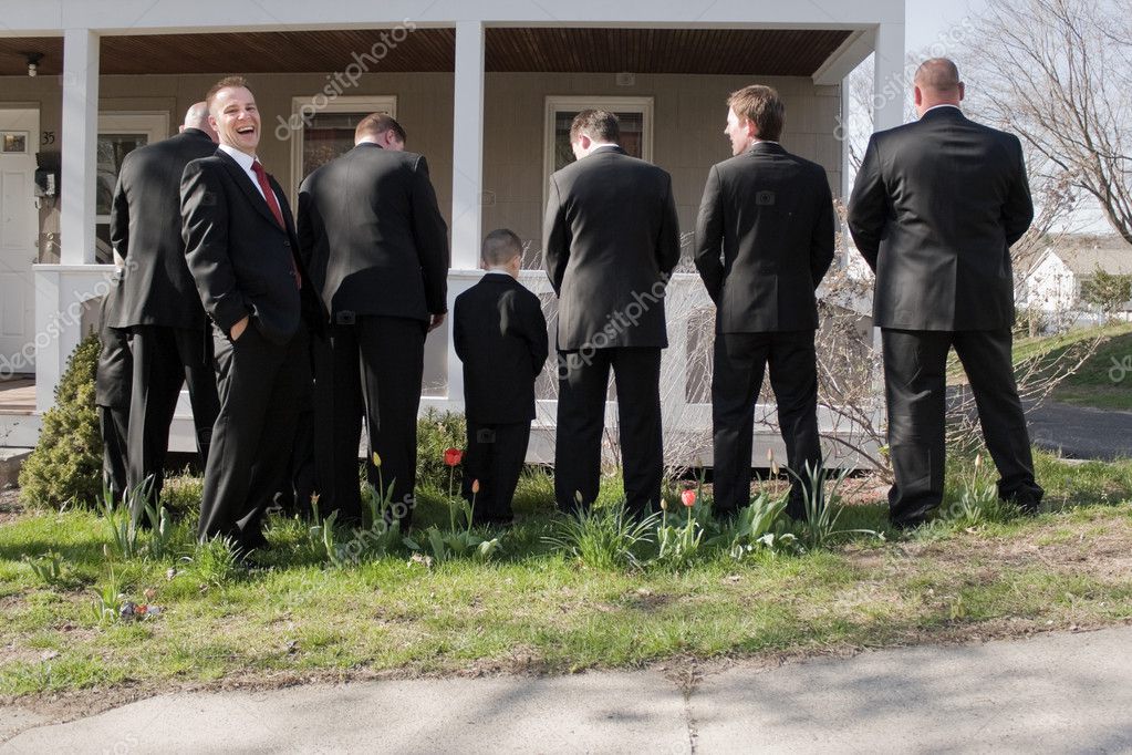 The groomsmen and other male members of a bridal party peeing in the bushes while the groom laughs. — Photo by ArenaCreative