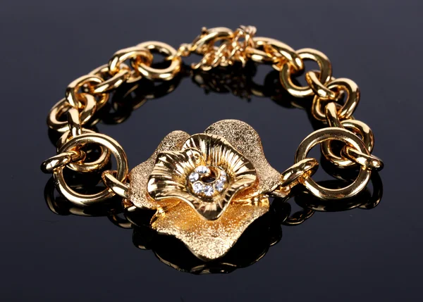 Beautiful golden bracelet with precious stones on grey background