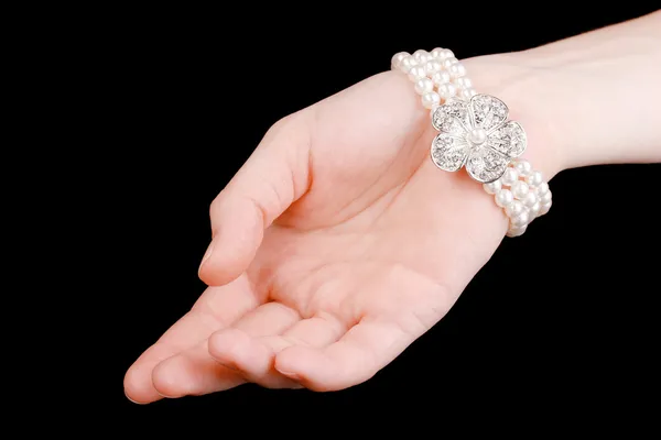 Pearl bracelet on hand isolated on black