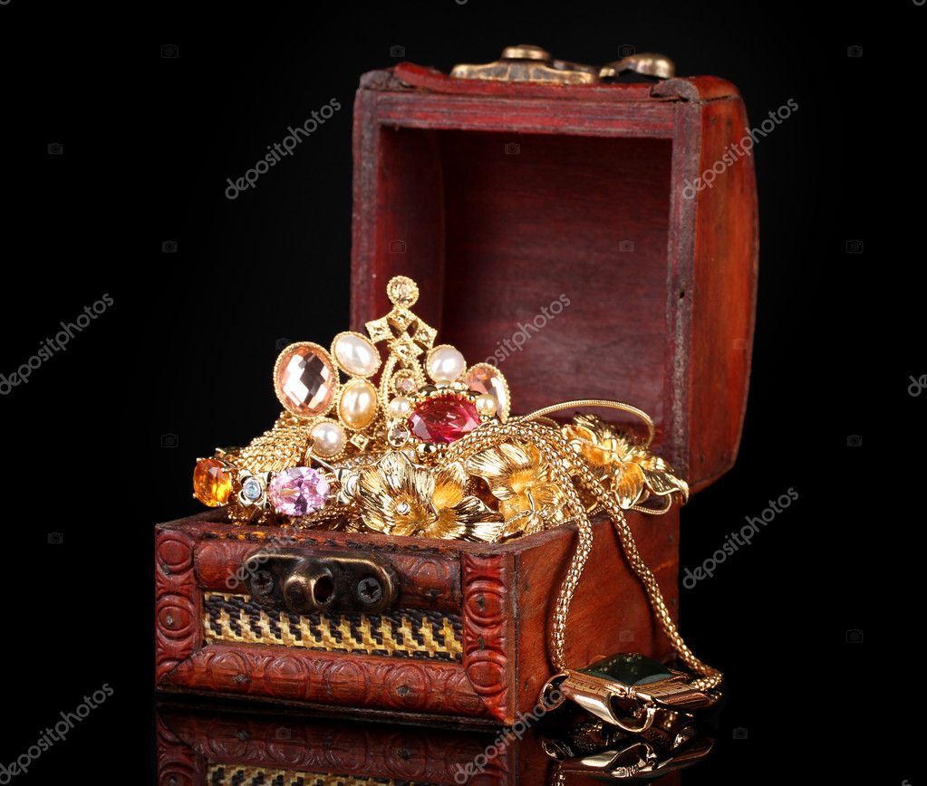 Wooden chest full of gold jewelry on black background - Stock Image