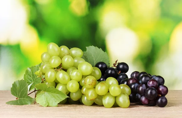 Ripe white and red grapes on green background