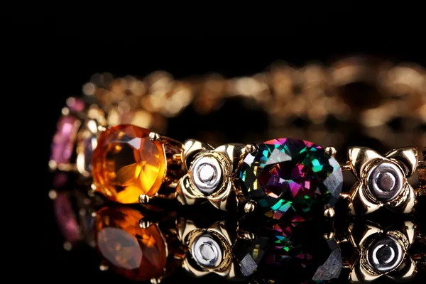 Beautiful bracelet with precious stones on black background