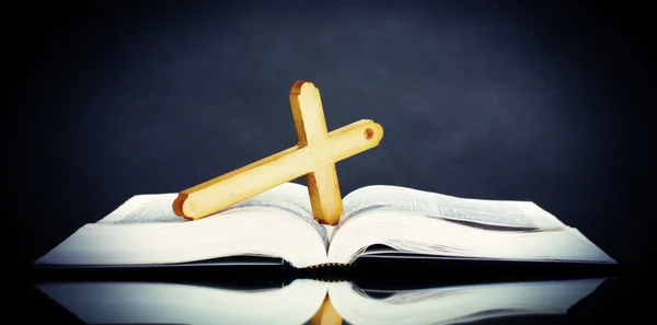 Russian bible and wooden cross on black background