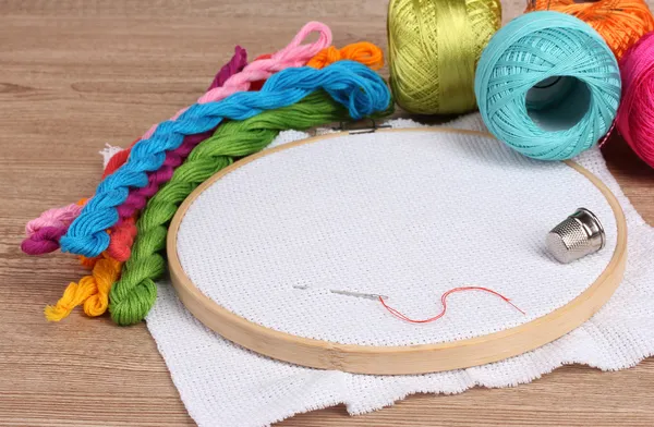 The embroidery hoop with canvas and bright sewing threads for embroidery in