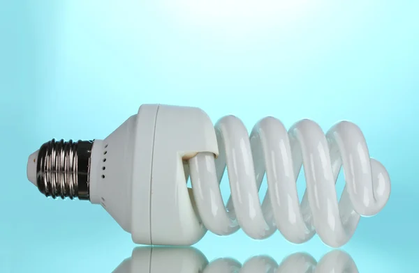 Energy saving light bulb on blue background