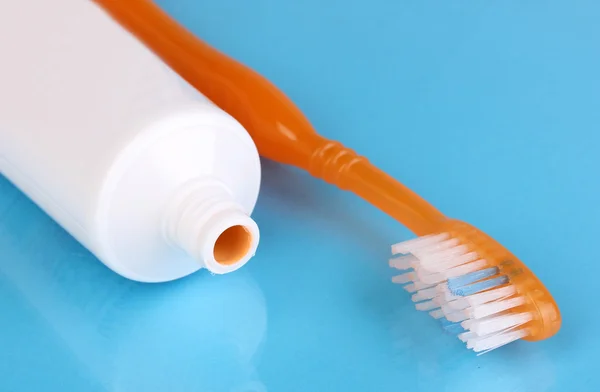 Toothbrush and paste on blue background