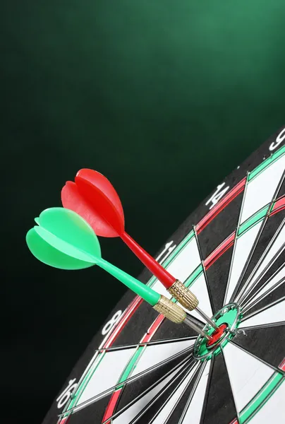 Dart board with darts on green background