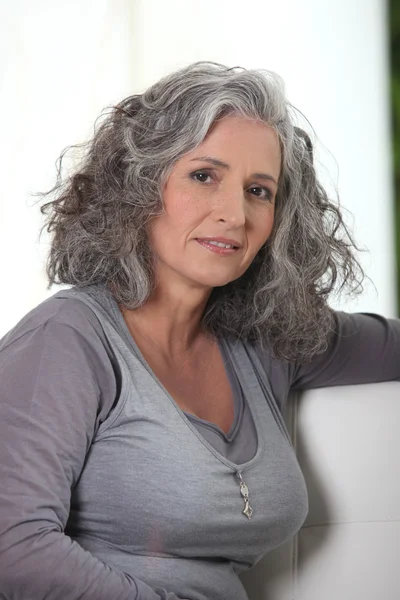 Grey-haired retired woman has a lot of free time