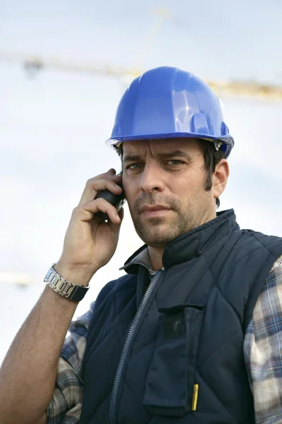 A workman at phone on a building site