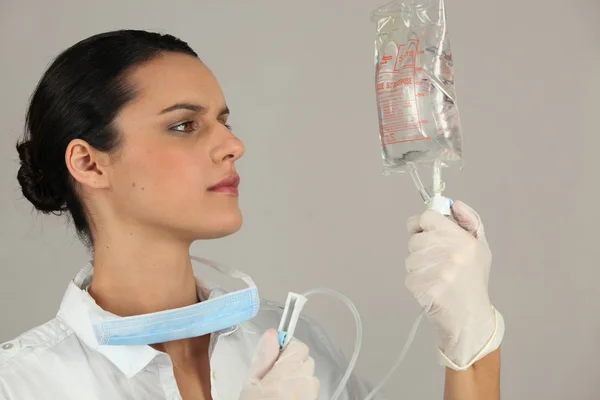 Hospital nurse examining a drip