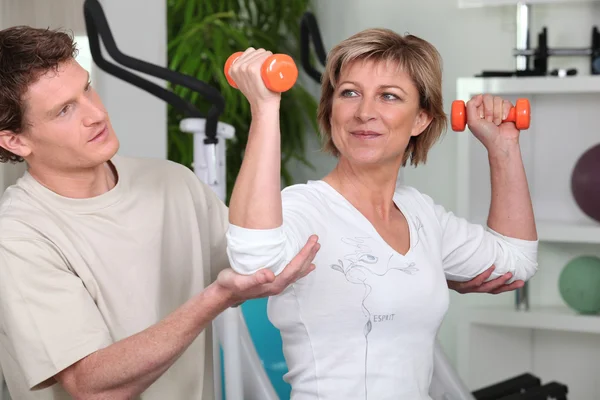 Mature woman working out with a personal trainer
