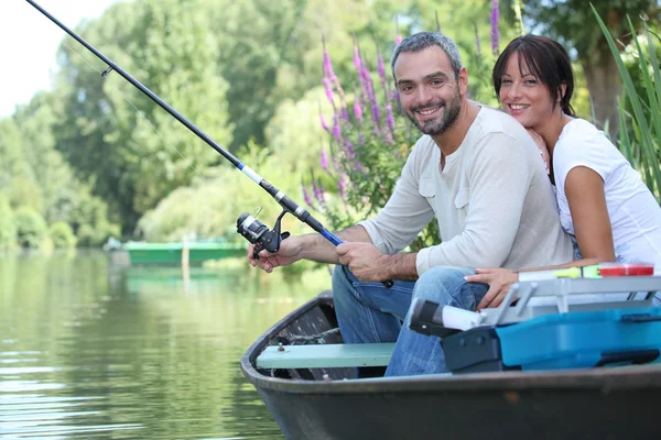 Couple in row boat fishing