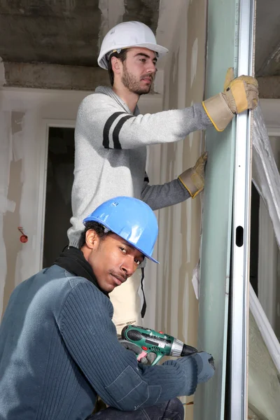 Tradesmen installing drywall