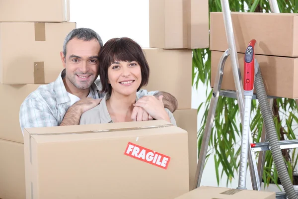 Couple stood by packed boxes