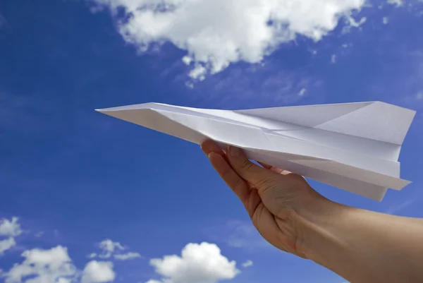 Female hand holding paper airplane